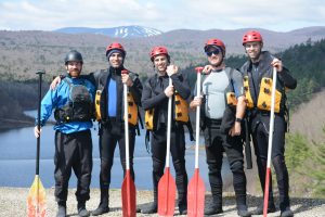 Group of people standing together in whitewater rafting gear