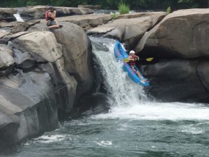 Person in funyak dropping down a short waterfall