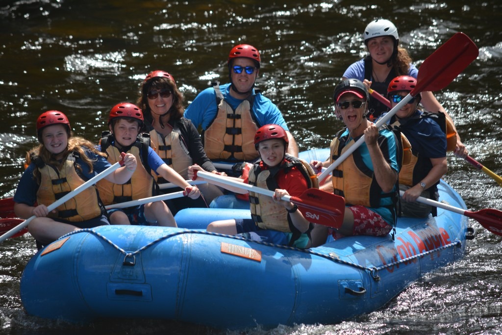 group of rafters floating on the river as they all pose for the camera