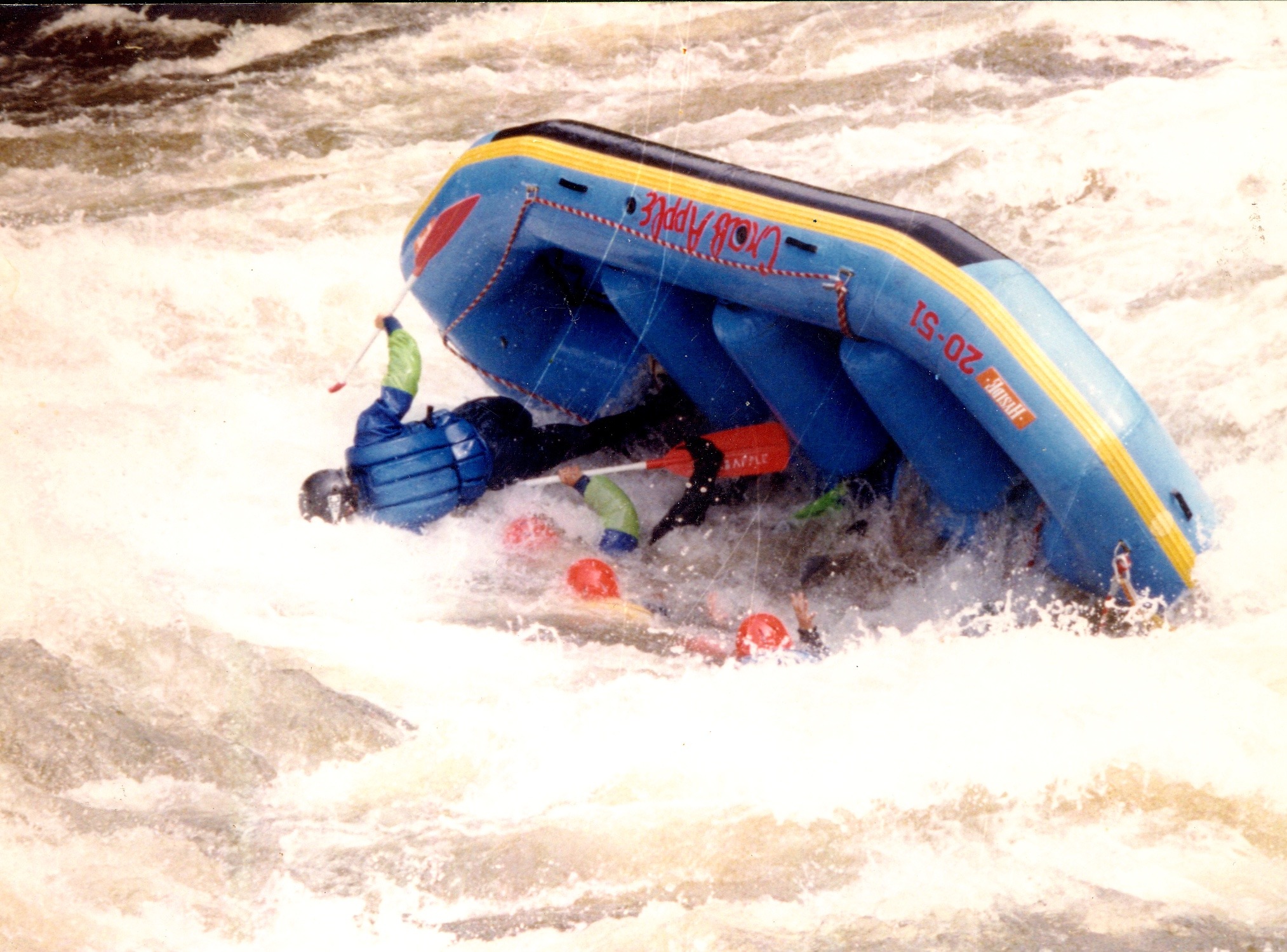 group of rafters falling in the water as their raft flips over