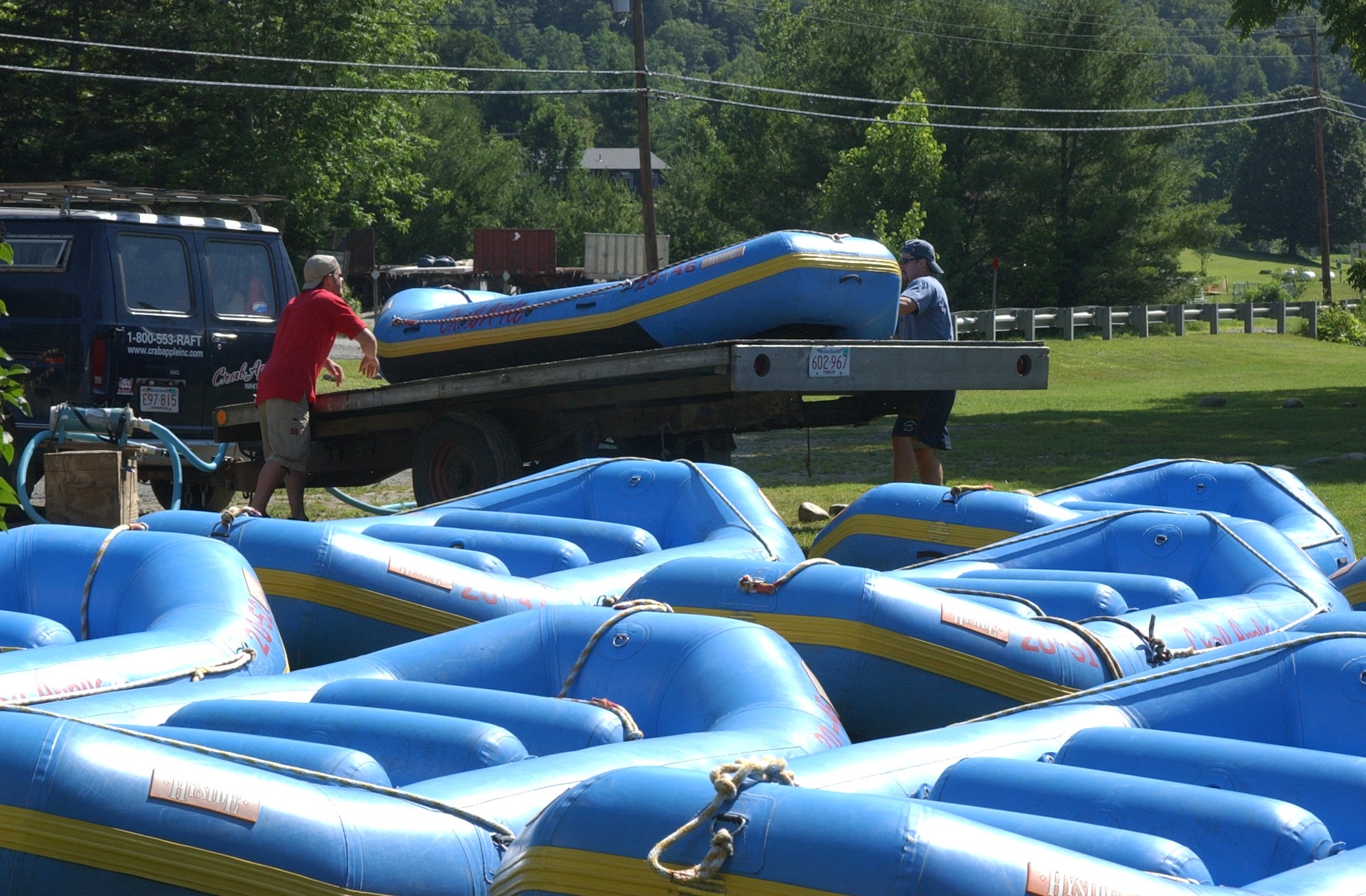 two men unloading rafts from a truck bed