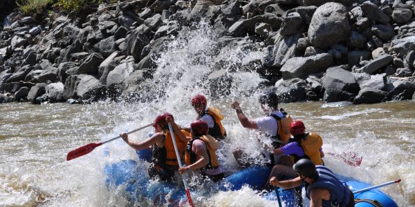 group of rafters going downhill and getting splashed by water