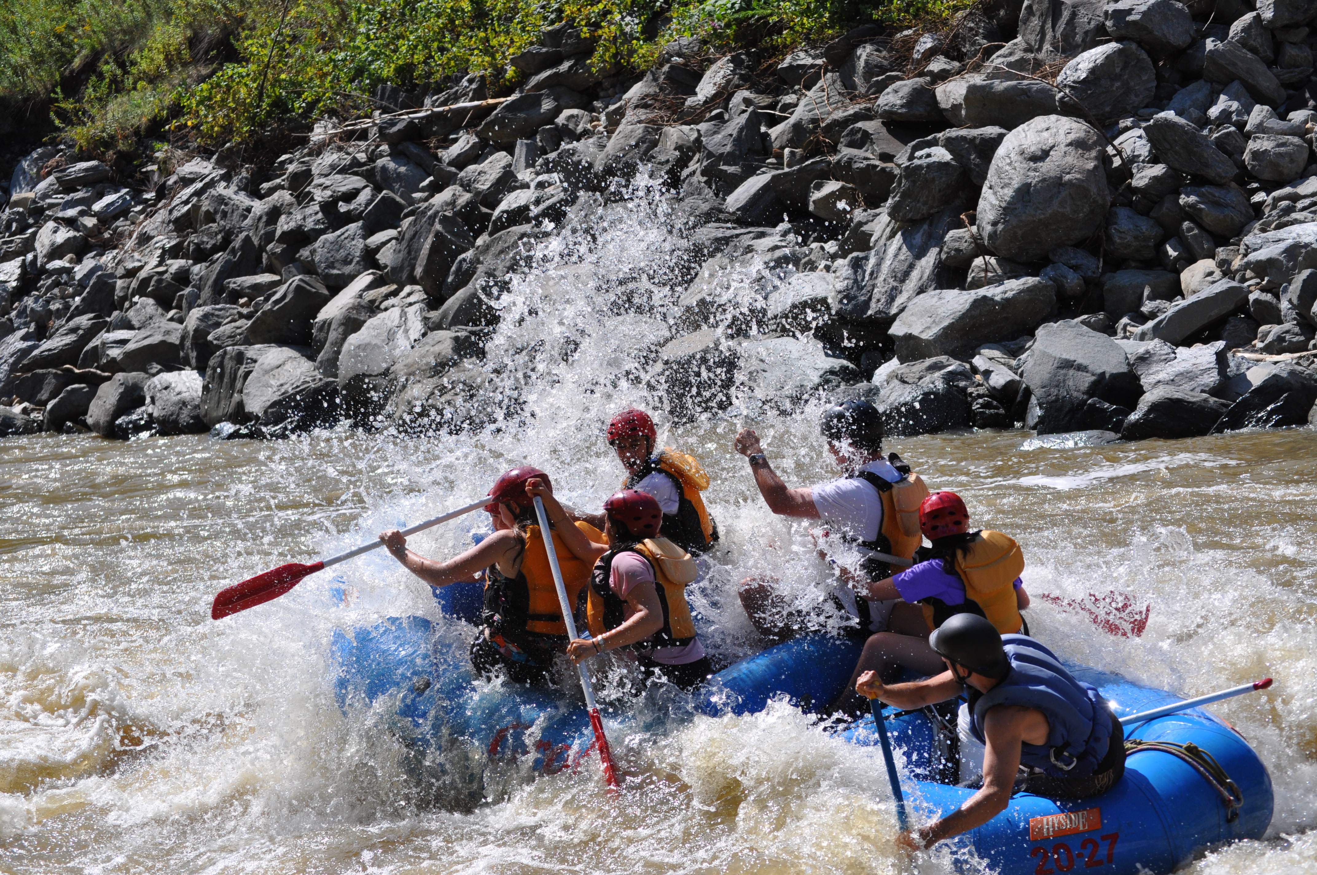 group of rafters going downhill and getting splashed by water