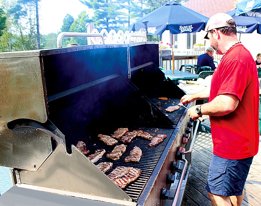 Man cooking steaks on an outdoor grill
