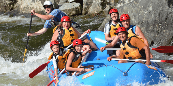 Family of 6 with guide in a whitewater raft on a river