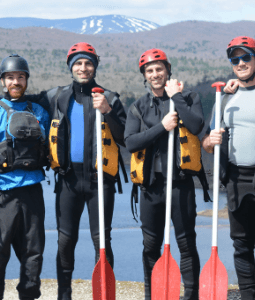 Bachelor party posing with their oars before rafting down a river.