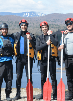 Bachelor party posing with their oars before rafting down a river.