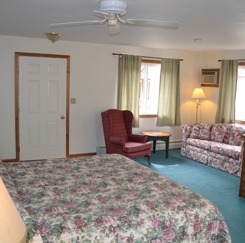 Suite bedroom with king-size bed, couch and armchair