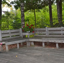 Moose Crossing outdoor porch with benches and a flower pot in the middle