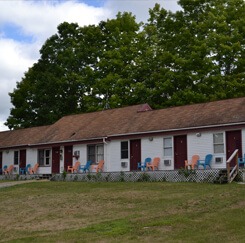Exterior of the lodge with blue and pink deck chairs overlooking the front lawn