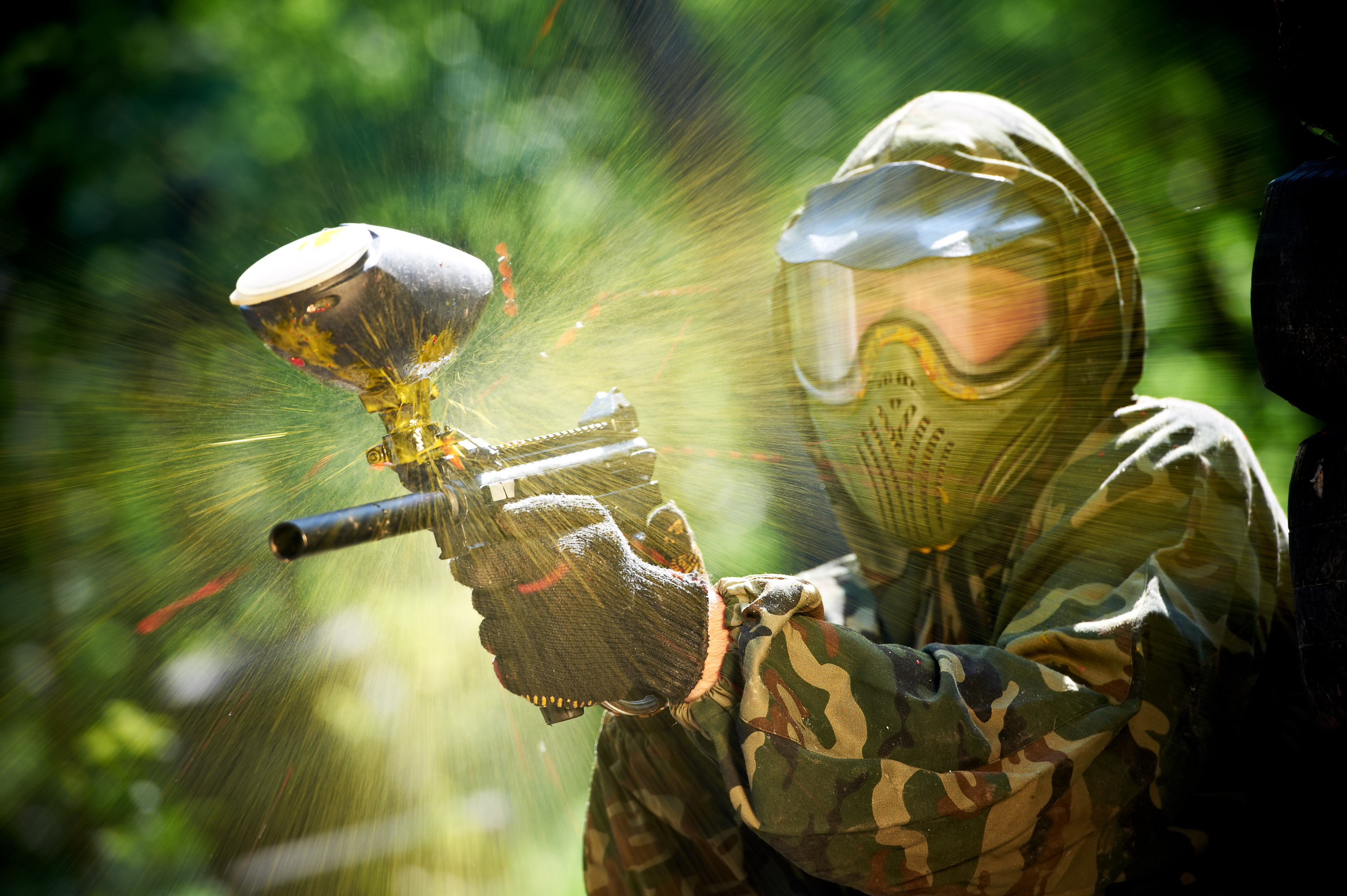 Paintballer firing a paintball gun.