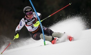 Paula Moltzan skiing downhill while avoiding an obstacle